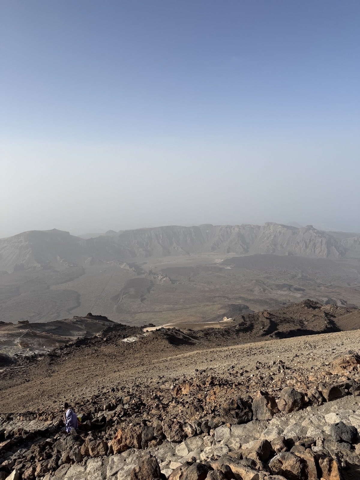 Walkers descending the rocky crater-rim path near the summit of Mount Teide