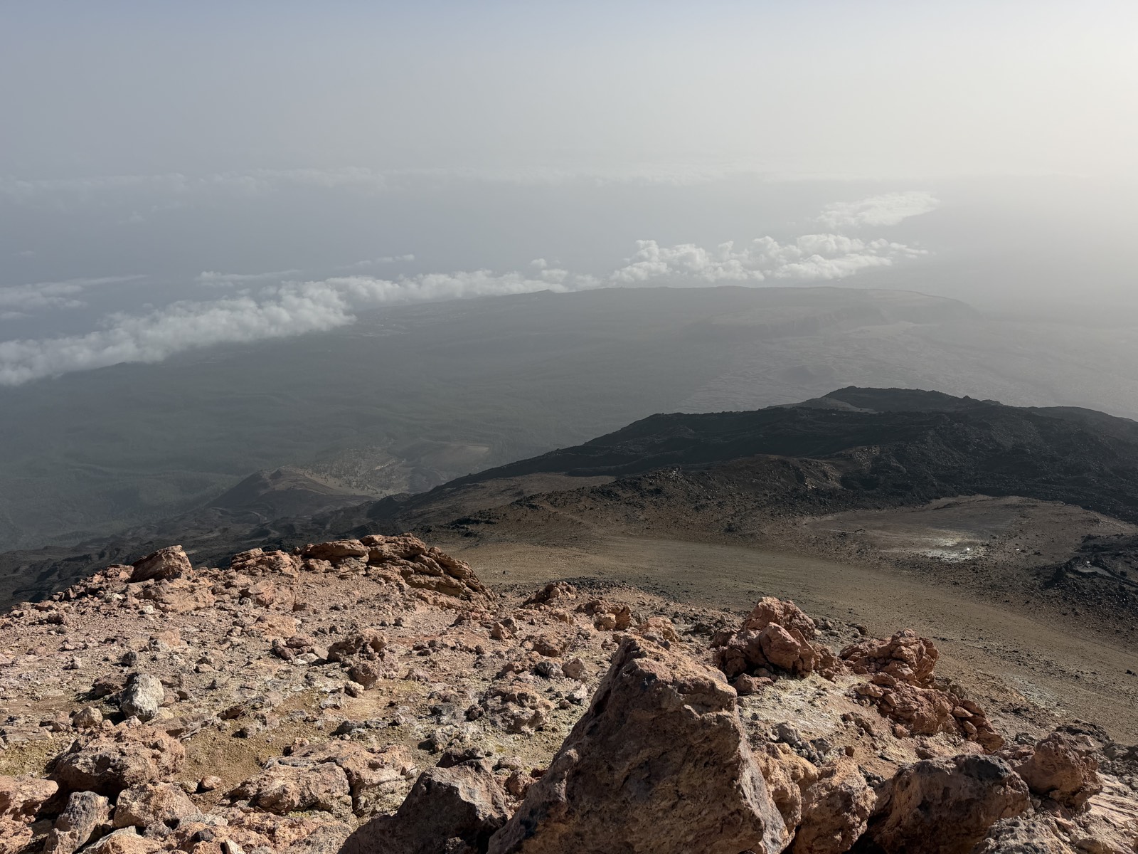 Sea of clouds covering the Tenerife coastline far below, seen from high on Mount Teide in early morning light