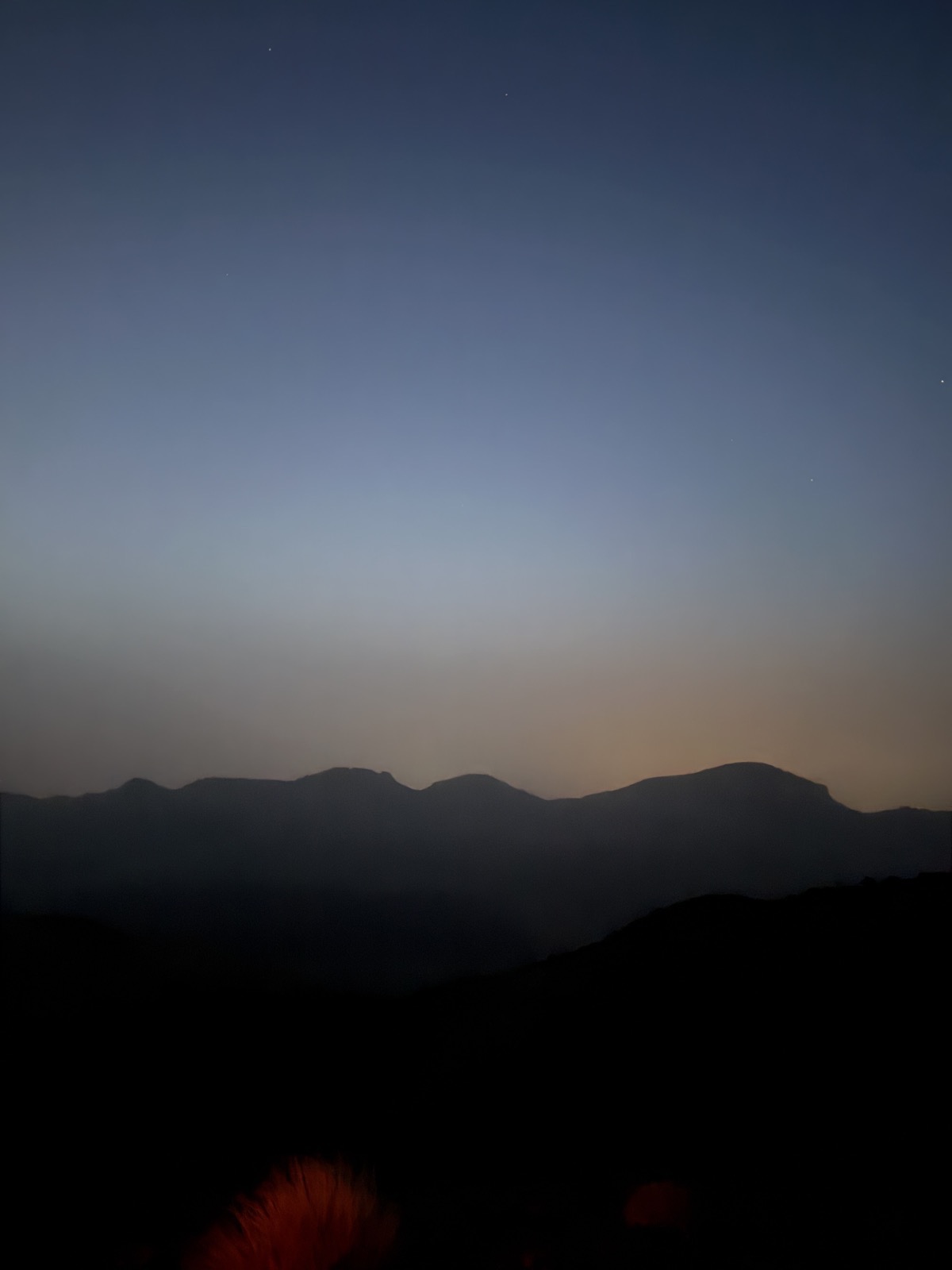 First light of sunrise breaking over a rocky volcanic ridge high on Mount Teide